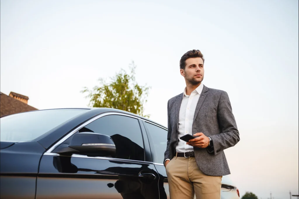 Man walking towards the driver-side door of his business car