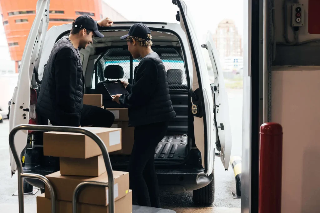 Courier van being loaded by delivery drivers
