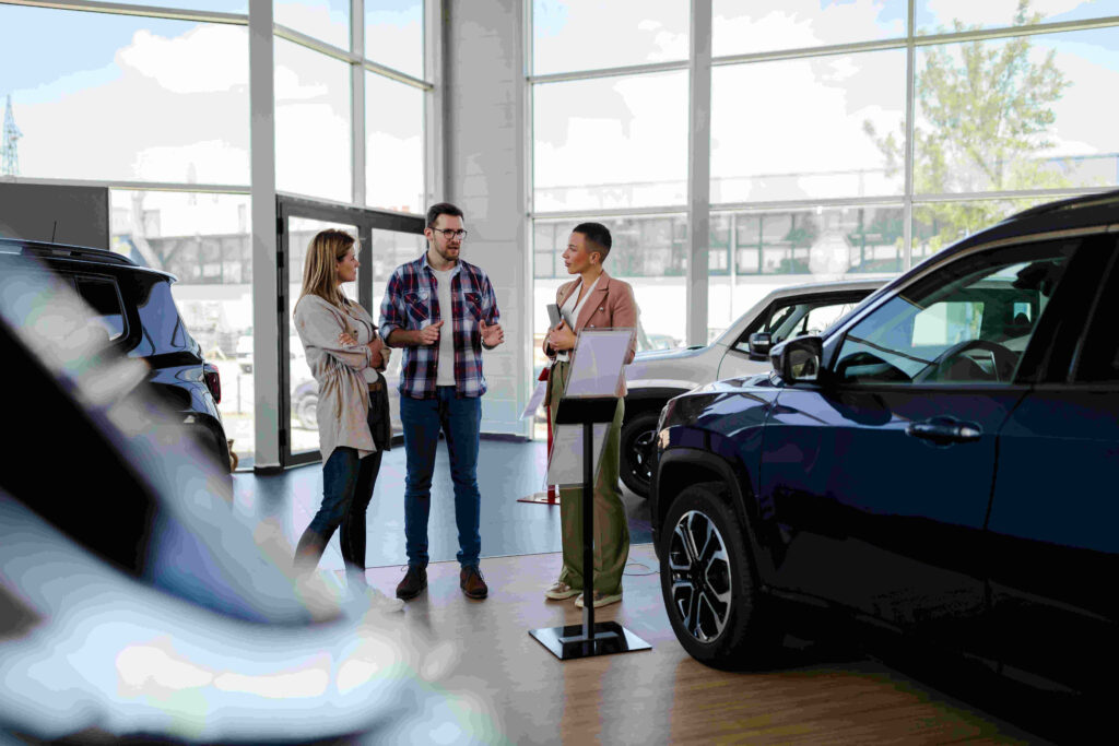 Young drivers stood in a car dealership